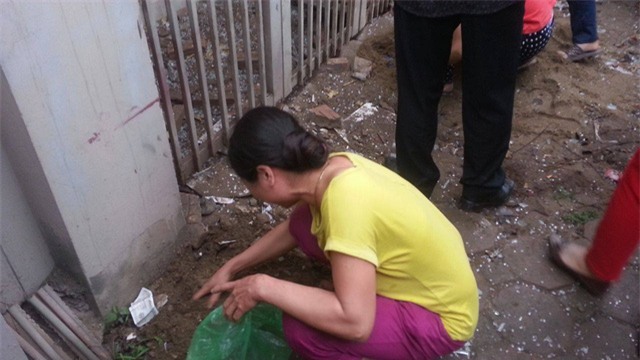 Một người phụ nữ đau đớn đi nhặt từng mảnh xác người thân.