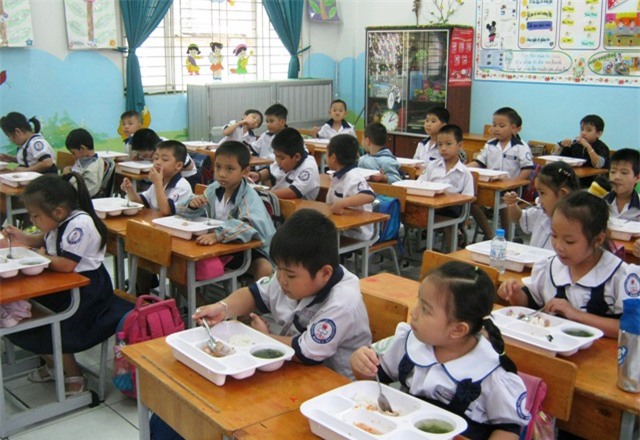 Nhiều trường học ở TPHCM phải tổ chức bữa ăn bán trú cho học sinh ngay trong lớp học (Ảnh: Hoài Nam)