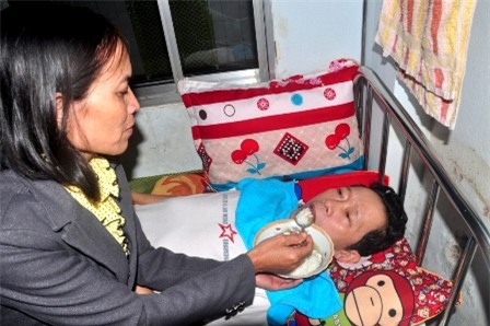 Cô Nhung bón từng thìa cơm cho chồng