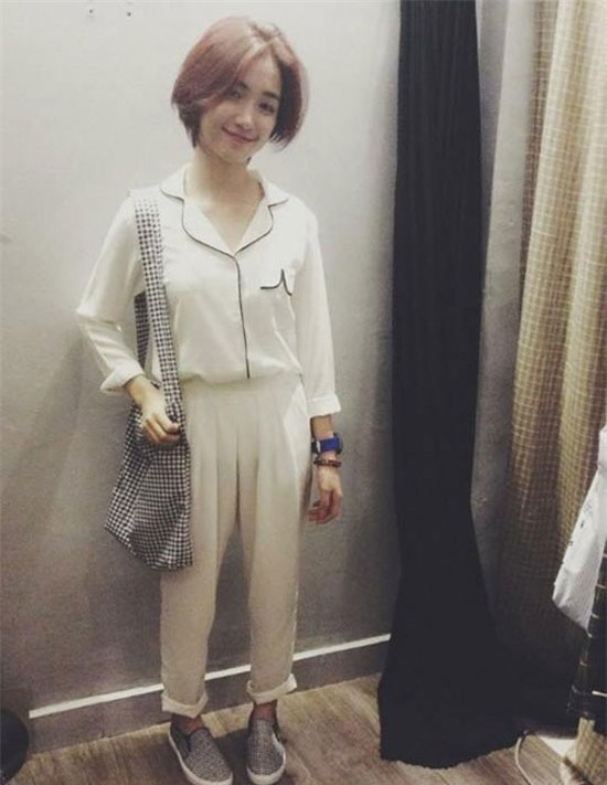Quán quân Học viên âm nhạc - Hòa Minzy trẻ trung với áo sơ mi pijama trắng, túi xách vải ca rô, giày slip -on năng động.