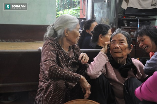 Cụ Nguyễn Thị Quyên (bên phải) đau đớn nhìn di ảnh cháu.