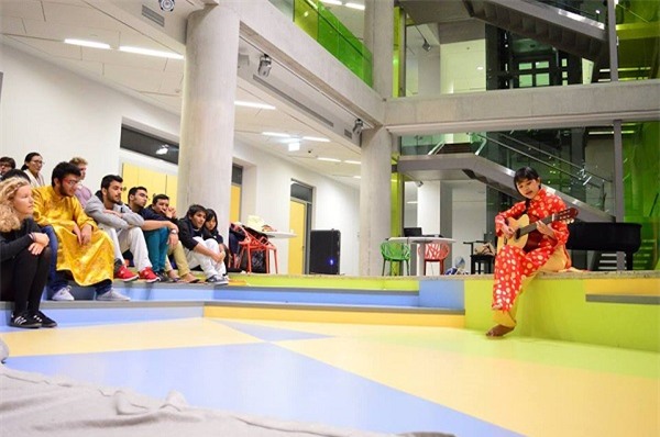 Dạ Thi mặc áo dài và thể hiện tài ca hát trong chương trình văn hóa châu Á tại trường UWC.