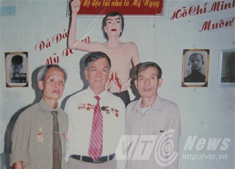 Ông Nghị (ngoài cùng bên phải) trước bức tượng tái hiện hành động đấu tranh năm xưa của mình