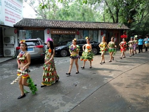 Những cô gái trẻ này không mặc quần áo hay váy vóc thông thường mà diện trang phục được làm từ những loại hoa quả, rau xanh vô cùng bắt mắt. Bộ trang phục khá hở hang, chỉ che được khoảng ngực và chiếc quần ngắn cũn của các cô gái.