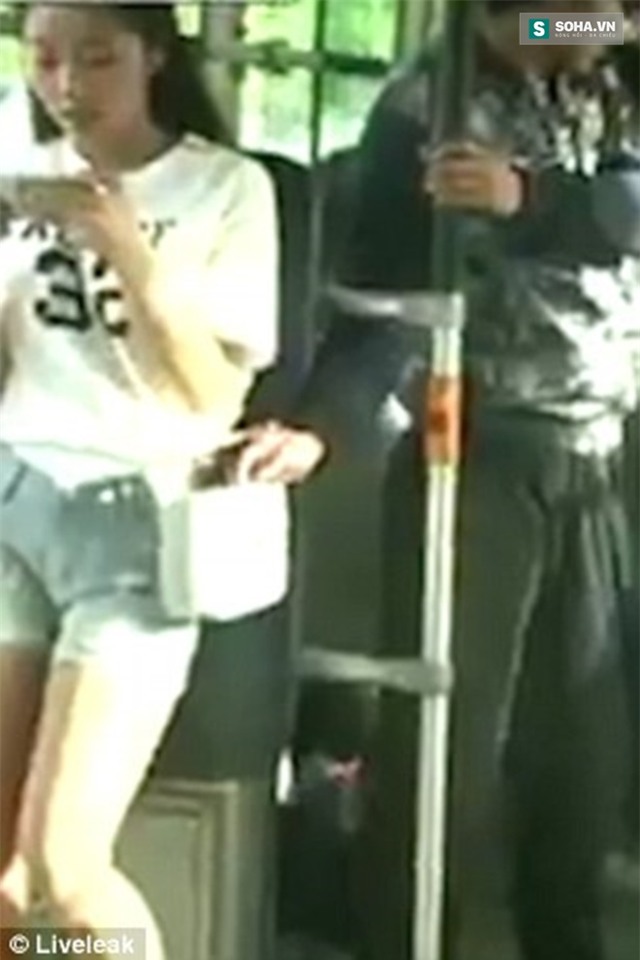  Một cô gái đang đứng trên xe buýt chăm chú nhìn điện thoại, đằng sau là một gã trông khá gian xảo thò tay vào túi xách của cô gái nhưng bị cô bắt được. 