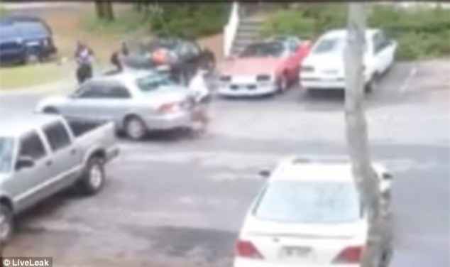 Cô gái chạy lại phía sau xe để nhặt vật nặng định chọi xe bạn trai một cú nữa...