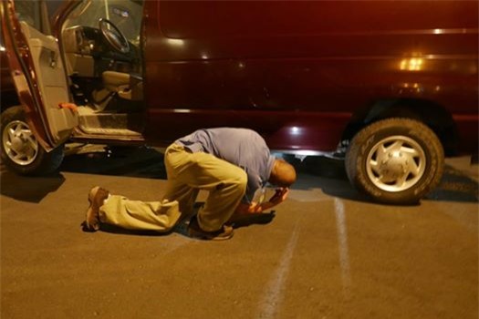 Nhân viên an ninh Mỹ kiểm tra gầm một chiếc xe chuẩn bị vào khu vực VIP