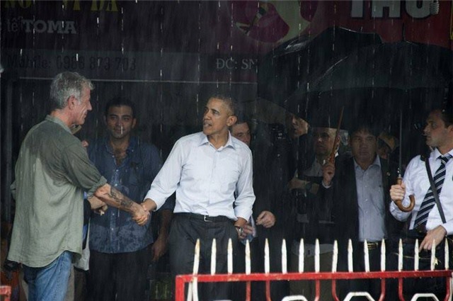 Đứng trú mưa khi dừng chân tại một khu chợ địa phương (được xác định là chợ Mễ Trì), Tổng thống Obama có thêm một kỷ niệm đáng nhớ tại Hà Nội (ảnh: AFP).