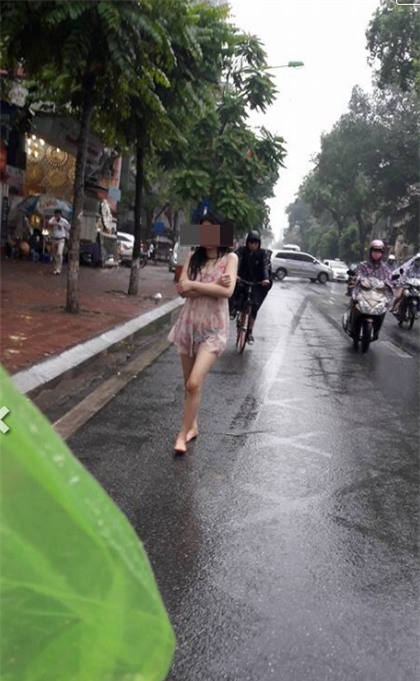 Hành động quá khó hiểu của cô gái giữa phố Hà Nội ngày mưa - Ảnh 4.