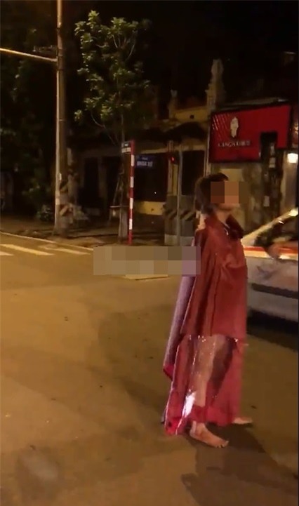 Người đàn bà mặc áo mưa đi giữa phố Hà Nội gây chú ý - Ảnh 1.