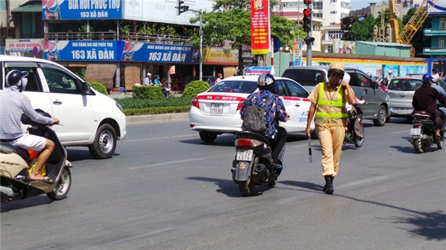 Chiến sĩ CSGT phơi mình giữa trời nắng xử lý vi phạm giao thông.