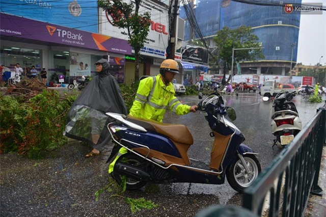 Hà Nội: Bất chấp nguy hiểm, gió to, người dân lao vào cứu 2 phụ nữ bị cây đè do bão - Ảnh 4.