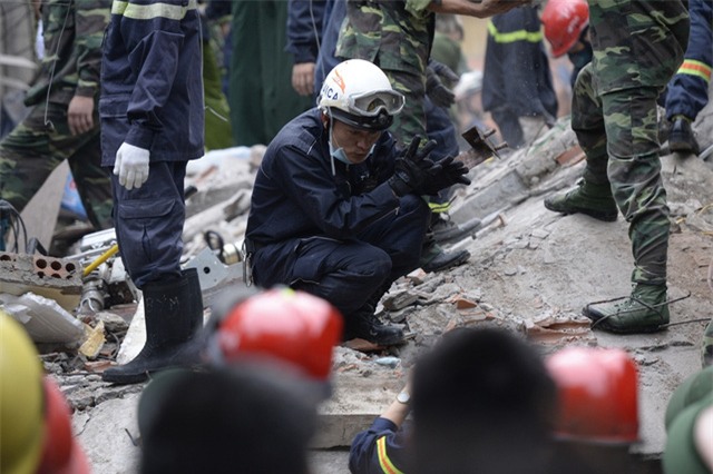Một nhân viên cứu hộ đang cố gắng tìm kiếm dấu hiệu của các nạn nhân bị vùi lấp. (Ảnh: Mạnh Thắng)