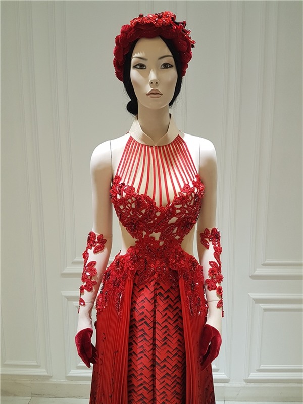 Nói về quyết định lựa chọn màu sắc này, Công Trí cho biết gam đỏ vô cùng phù hợp với tính cách và tạo hình của Lan Ngọc trong bộ phim qua vai nàng Cám đanh đá. Bên ngoài lớp họa tiết đan lát là chi tiết xếp li hợp xu hướng mềm mại nhưng vẫn nổi loạn bởi hiệu ứng loang màu đỏ, đen.