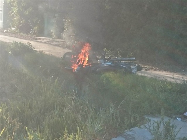 Cãi nhau, hai vợ chồng lần lượt mang xe máy của gia đình ra để đốt. Ảnh: Lê Chung