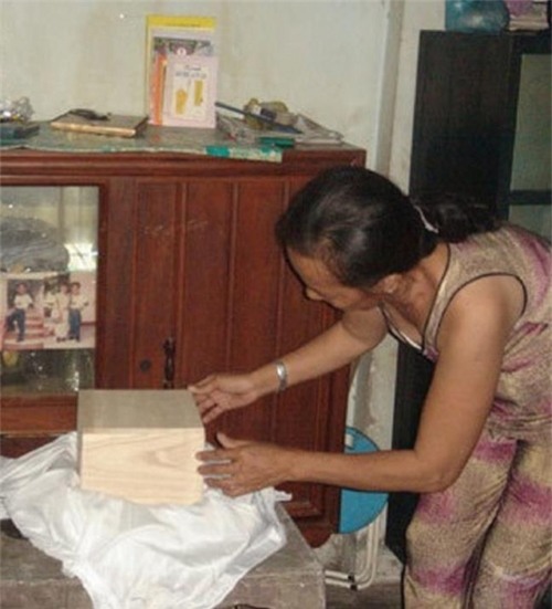 Bà Kim Anh bên hũ tro cốt của con gái.