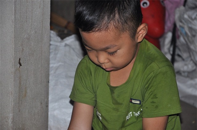 Cậu bé Vinh buồn rầu ngồi 1 mình thương bố.