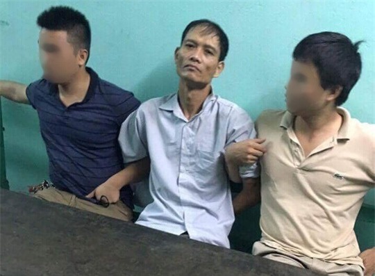 Nghi phạm Doãn Trung Dũng (giữa) khi bị bắt giữ