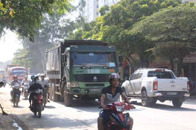 Xe tải hạng nặng lưu thông cùng với dòng người trên đường 70. Ảnh: Hà Phương