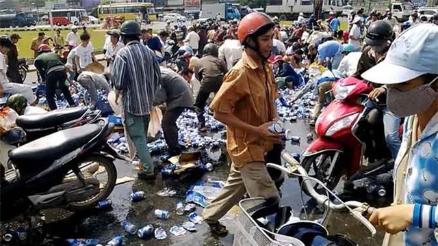  Hàng trăm người xông vào cướp bia tại khu vực vòng xoay Tam Hiệp, TP Biên Hòa, Đồng Nai trong sự bất lực của tài xế. (Ảnh: Tuổi trẻ)