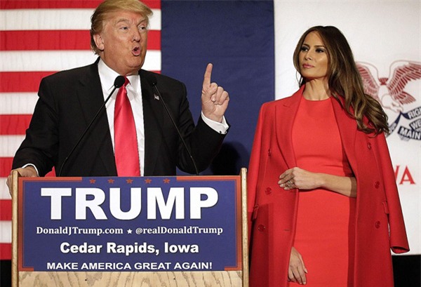 ... với bộ đầm đỏ trơn màu tôn dáng và khoác ngoài bằng áo khoác dáng dài cùng tông màu.