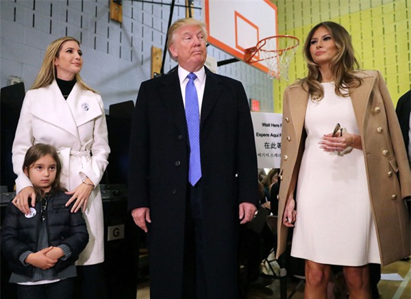 Cựu người mẫu khoác trên mình chiếc váy Michael Kors dáng suông thanh lịch, choàng hờ áo Balmain màu camel thời thượng. Bộ váy của phu nhân Melania Trump đồng điệu cùng sơmi trắng của chồng và áo khoác dáng dài của cô con gái xinh đẹp tài năng: Ivanka Trump