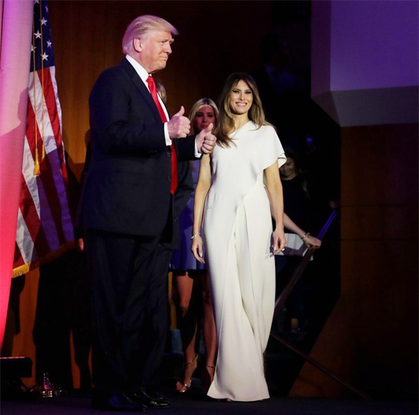 Melania cũng thường xuyên diện sắc trắng nhằm tạo nên sự kết nối đồng điệu với chồng. Bà xã gợi cảm của ông xuất hiện nổi bật trong bộ jumpsuit trắng lệch vai nữ tính, yêu kiều. Thiết kế lụa cao cấp từ thương hiệu Ralph Lauren được bán lẻ ở mức 3.990 USD (gần 90 triệu đồng).