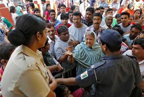 Người dân cãi vã với lực lượng an ninh sau khi bị ngăn vào một ngân hàng ở TP Mumbai hôm 12-11 Ảnh: REUTERS