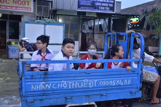 Một số em nhỏ được bố mẹ thuê xe ba gác chở đến trường