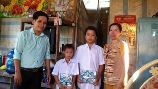 Thầy Nam trao trao sách, vở cho học trò nghèo.