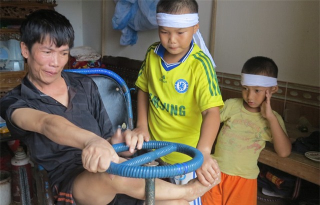 Thành dạy cho em cách giúp đỡ cha lên xe lăn.