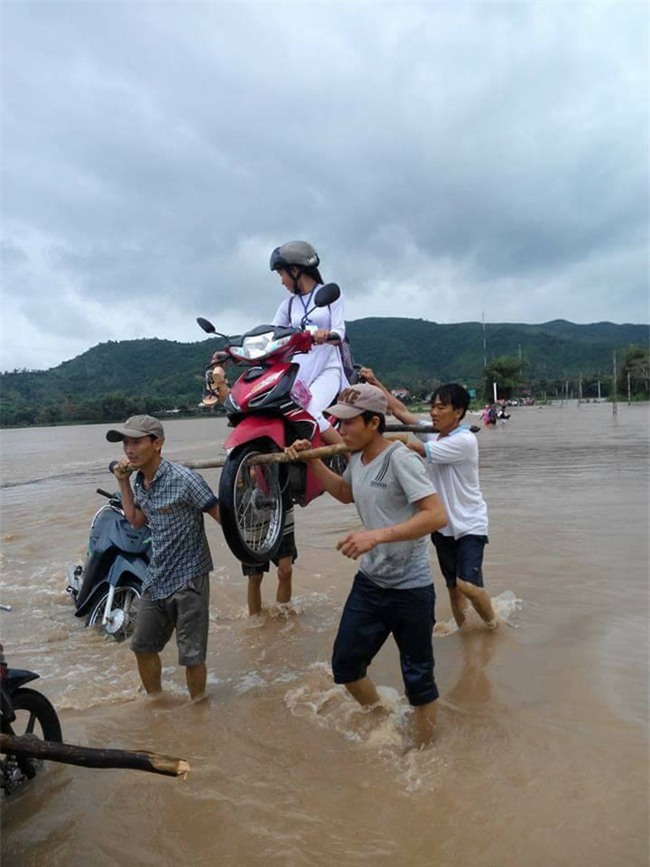 4 soái ca dùng thanh gỗ khiêng nữ sinh cùng chiếc xe máy qua vùng lũ - Ảnh 2.