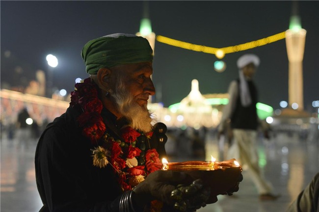 Một tín đồ đạo Hồi ở Pakistan đang giữ trên tay một ngọn đèn dầu đứng cầu nguyện trong đền thờ ở thành phố Lahore, Pakistan.