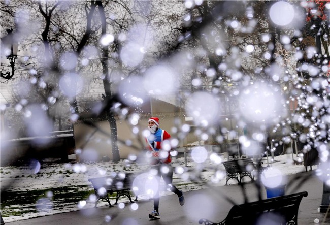 Một người đàn ông Romania trong bộ phục trang ông già Noel đang tham gia một cuộc thi chạy gây quỹ từ thiện tổ chức ở thành phố Bucharest, Romania.