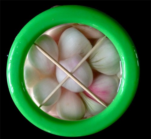 Xếp hành vào lọ, dùng tăm tre chèn trên mặt để hành không bị thâm (Ảnh: Khám phá)