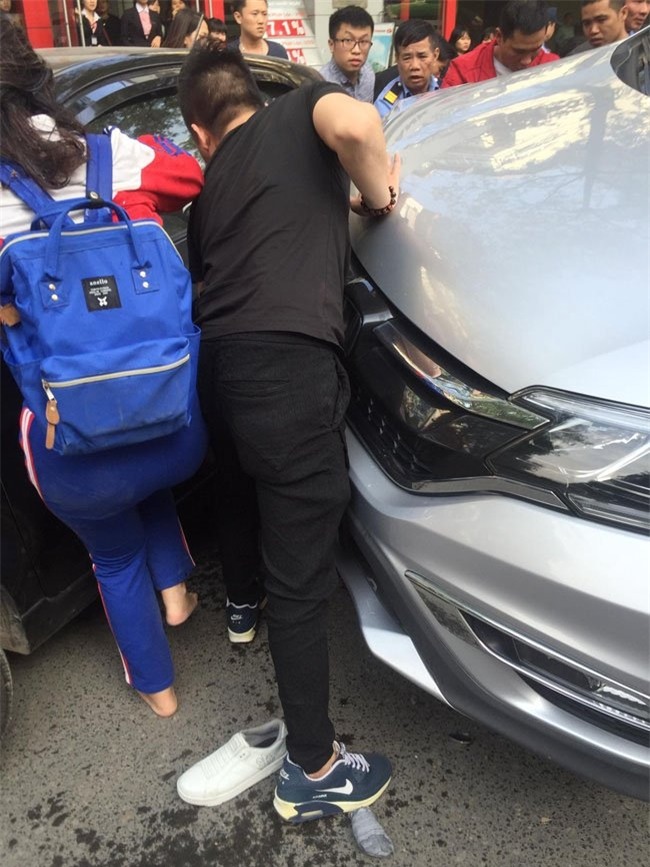 Hàng chục người nâng 'xe điên' cứu cháu bé mắc kẹt