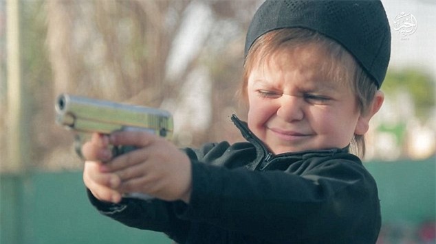 Rùng mình khoảnh khắc đứa trẻ vài tuổi dùng súng hạ sát một tù nhân IS - Ảnh 1.