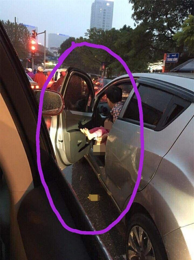 Ông bố mở cửa ô tô cho con đi vệ sinh khi dừng đèn đỏ ngay trên phố Hà Nội - Ảnh 1.