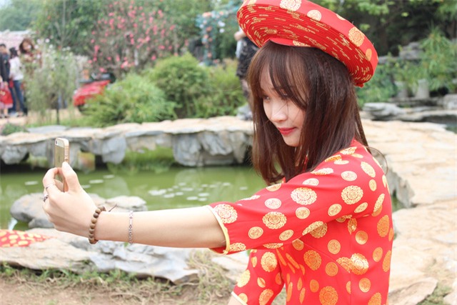 Một bạn gái mãi mê tự sướng trong bộ trang phục áo dài đỏ.