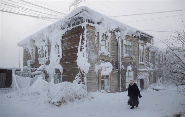 Một phụ nữ đi qua một ngôi nhà đông lạnh ở trung tâm ngôi làng