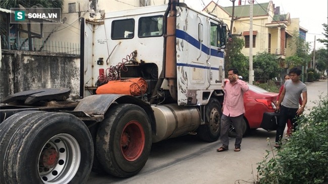 Xế hộp Nissan bị xe container đẩy lùi hàng chục mét, anh trai đạp cửa cứu 2 em - Ảnh 1.