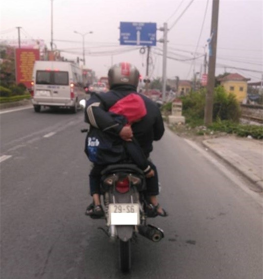 Nguoi cha vua lai xe may vua om con ngu tren duong quoc lo hinh anh 1
