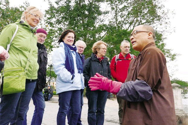 Thượng tọa Thích Tịnh Giác nhiệt thành thuyết giảng cho du khách về tục lệ thả cá chép hôm 23 tháng Chạp vừa qua. Ảnh: TL