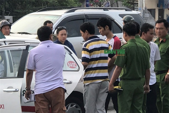 Nghi can Duy (áo thun trắng, tay đỏ) được di lý đến hiện trường để thực nghiệm điều tra.