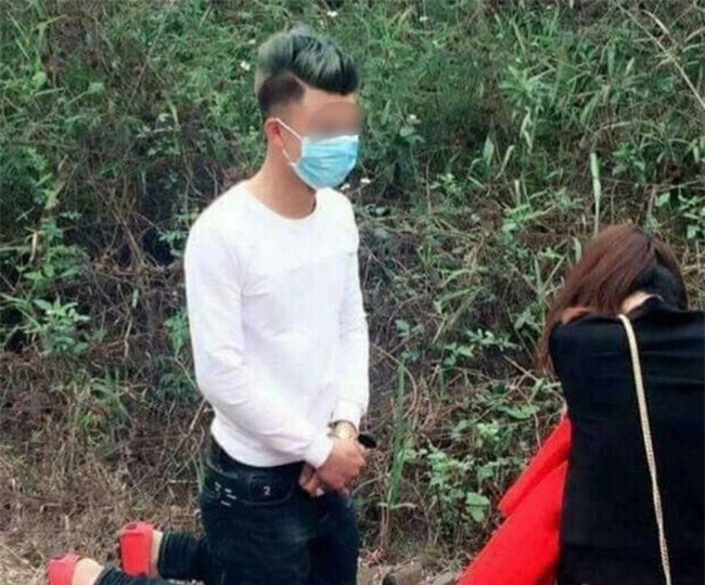 Chang trai quy goi xin loi ban gai tren duong di le chua hinh anh 1