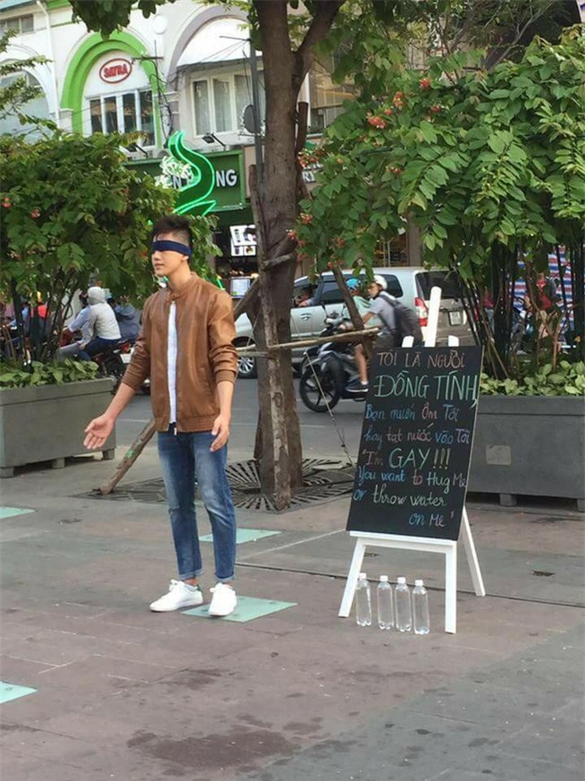 Chàng trai gây chú ý khi bịt mắt giữa phố đi bộ cùng tấm bảng Tôi là gay, bạn sẽ ôm tôi hay tạt nước? - Ảnh 1.