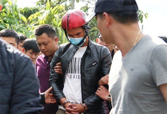 Lực lượng chức năng dẫn giải hung thủ Nguyễn Thành Đức đến nơi khai quật tử thi nạn nhân.