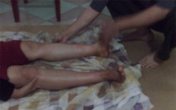 Hình ảnh thầy Thịnh ngồi đắp thuốc cho bệnh nhân.