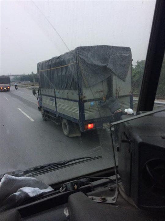 Hình ảnh nam thanh niên đứng trên xe máy, đu bám xe tải đầy nguy hiểm - Ảnh 2.
