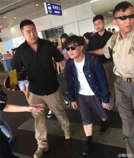 Trần Dịch Tấn quá là bé nhỏ so với các chàng vệ sĩ ngoài sân bay.